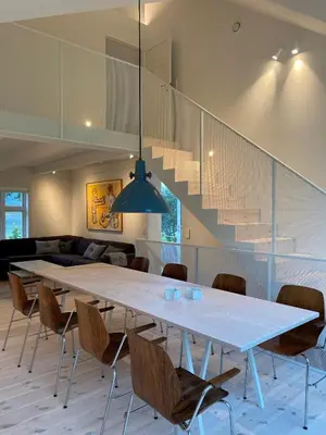 a dining room with a large white table and chairs at Storlauvøya The Atlantic Ocean Road in Karvåg
