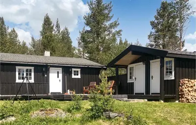 a black and white cabin with a porch at 3 Bedroom Cozy Home In Røros in Røros