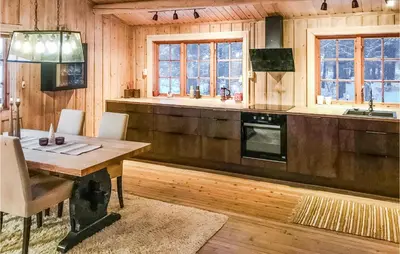 a dining room with a table and a kitchen at 3 Bedroom Cozy Home In Røros in Røros