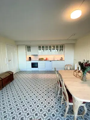 a kitchen with a table and chairs in a room at Storsand Gård in Trondheim