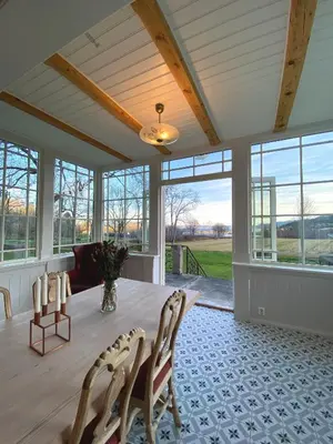a dining room with a table and chairs and windows at Storsand Gård in Trondheim