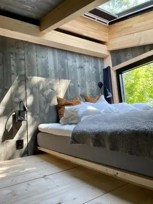 a bedroom with a bed in a wooden wall at Fuglekassehytta in Sparbu