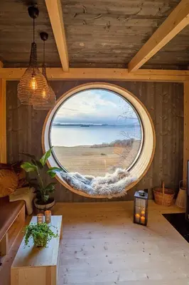 an oval window in a room with a view of the ocean at Fuglekassehytta in Sparbu