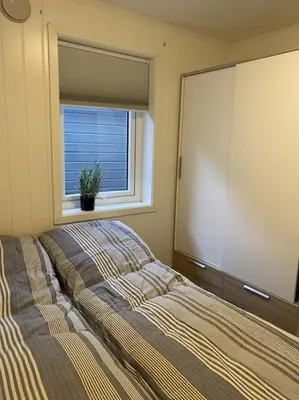 a bedroom with a bed and a large window at Helt ny rorbu på Slyngstad i Ålesund Kommune in Ålesund