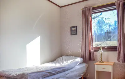 a bedroom with a bed and a window at Stunning Home In Skånevik With Kitchen in Skånevik