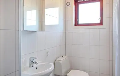a white bathroom with a toilet and a sink at Stunning Home In Skånevik With Kitchen in Skånevik