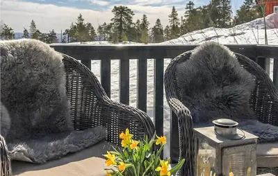 two wicker chairs sitting on a porch with flowers at Beautiful Home In Noresund With Wifi in Noresund