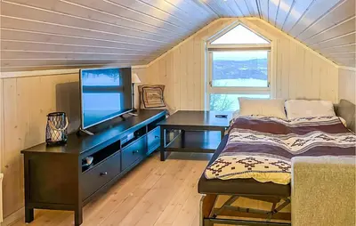 a bedroom with a desk with a television and a bed at Beautiful Home In Noresund With Wifi in Noresund