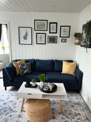 a living room with a blue couch and a coffee table at Light home apartment Alesund with free parking in Ålesund