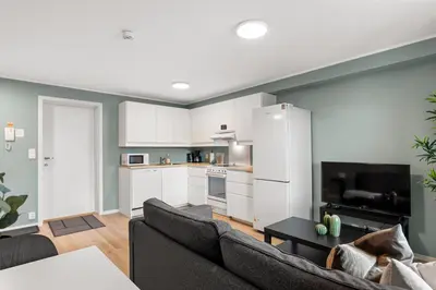 a living room with a couch and a kitchen at Forenom Serviced Apartments Bergen Skottegaten in Bergen