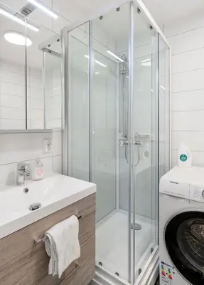 a bathroom with a shower and a washing machine at Forenom Serviced Apartments Bergen Skottegaten in Bergen