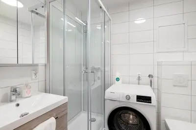 a bathroom with a washing machine in a shower at Forenom Serviced Apartments Bergen Skottegaten in Bergen