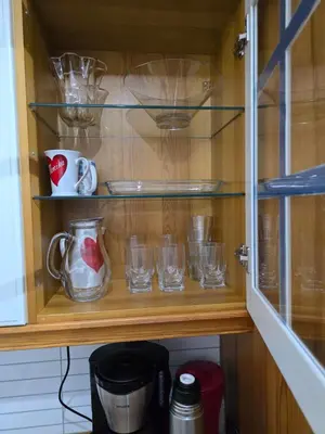 a cupboard with glasses and cups on it at Florvåg -flott utsikt mot byen in Florvåg