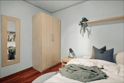 a bedroom with a bed and a wooden cabinet at Bergen city center apartment in Bergen
