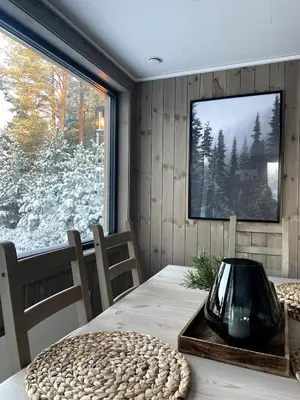 a dining room with a table and a large window at A cottage by the forest with a sea view ! in Søfstad
