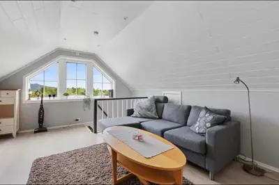 a living room with a couch and a table at Leilighet med gratis parkering og WiFi in Kristiansund
