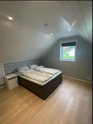 a bedroom with a bed in a attic with a window at Leilighet med gratis parkering og WiFi in Kristiansund