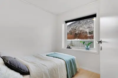 a white bedroom with a bed and a window at Stor og moderne leilighet i Indre Arna Bergen GRATIS PARKERING!! in Bergen