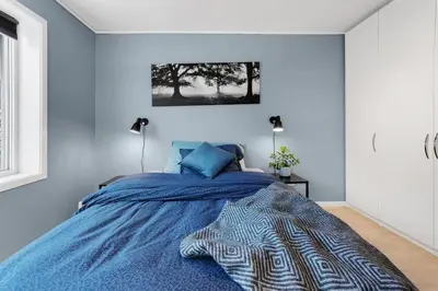 a bedroom with a bed with a blue comforter at Stor og moderne leilighet i Indre Arna Bergen GRATIS PARKERING!! in Bergen