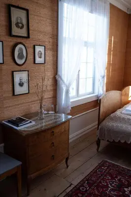 a bedroom with a dresser and a window and a bed at Hoel Gård - Herregården ved Mjøsa in Nes i Ådal