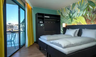 a hotel room with two beds and a balcony at Thon Hotel Ålesund in Ålesund