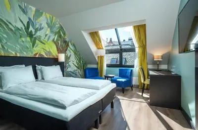 a bedroom with a bed and a desk and a window at Thon Hotel Ålesund in Ålesund