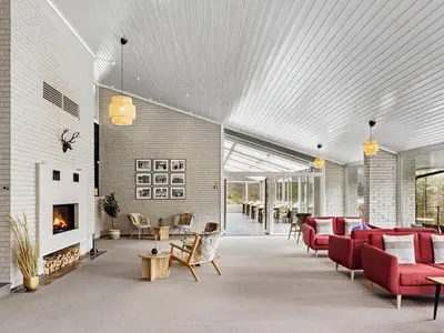 a living room with red furniture and a fireplace at Eidfjord Hotel in Eidfjord
