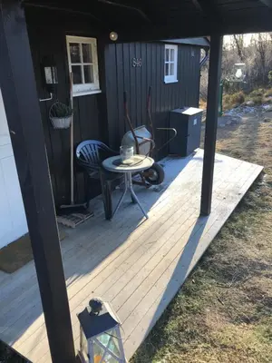 a wooden deck with a table and a chair at Cabin in the Mountain, with Solar Energy in Slidre