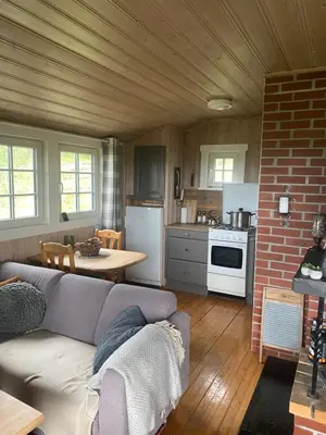 a living room with a couch and a kitchen at Cabin in the Mountain, with Solar Energy in Slidre