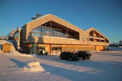 a building with two cars parked in front of it at Leilighet med panoramautsikt Sjusjøen Innendørs parkering in Sjusjøen