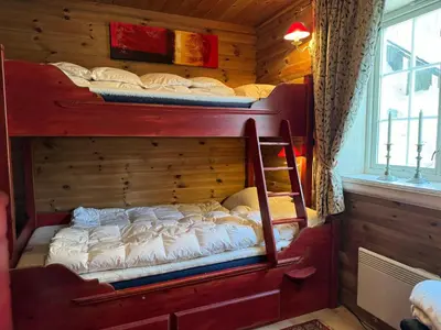 a bedroom with two bunk beds in a cabin at Bjødnabakkens historie in Beitostøl