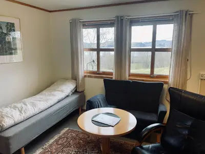 a living room with a couch and chairs and a table at Nye Heimen Overnatting in Namsos
