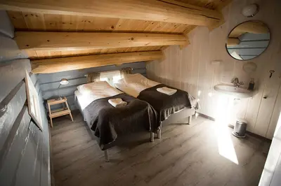 a bedroom with a bed and a sink in a attic at Billingen Seterpensjonat in Skjåk