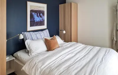a bedroom with a bed with white sheets and pillows at Gorgeous Home In Revsnes With Wifi in Refsnes