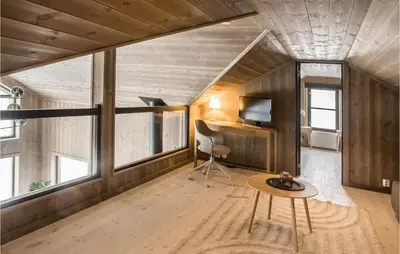 a room with a table and a chair and some windows at 4 Bedroom Lovely Home In Østby in Østby