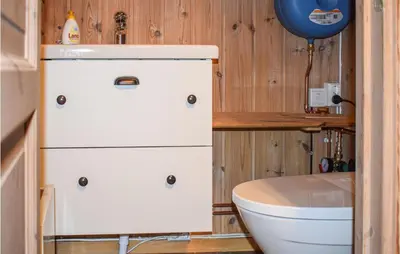 a small bathroom with a toilet and a sink at Cozy Home In Tuddal With Kitchen in Tuddal
