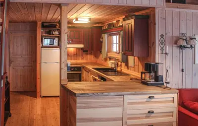 a kitchen with wooden cabinets and a white refrigerator at Cozy Home In Tuddal With Kitchen in Tuddal