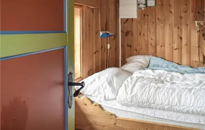 a bed in a room with a wooden wall at 2 Bedroom Stunning Home In Rauland in Rauland