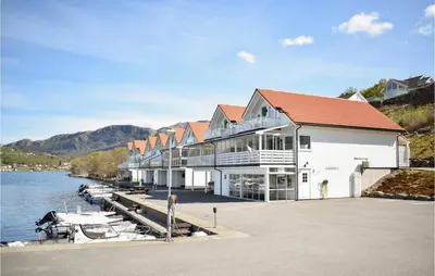 a large building with a dock next to the water at 4 Bedroom Lovely Home In Vikebygd in Vikebygd