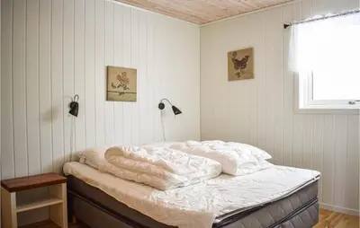 a bedroom with a bed with white sheets and a window at 4 Bedroom Lovely Home In Vikebygd in Vikebygd