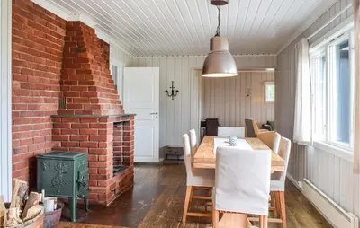 a dining room with a table and a brick wall at Nice Home In Sjusjoen in Sjusjøen