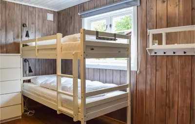 a bunk bed in a room with wooden walls at Nice Home In Sjusjoen in Sjusjøen