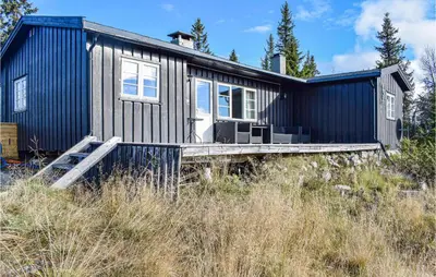 a black house with a blue siding at Nice Home In Sjusjoen in Sjusjøen