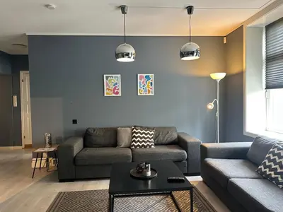 a living room with a couch and a table at Ålesund City Center - Modern 80-m2 flat with 3 bedrooms in Ålesund