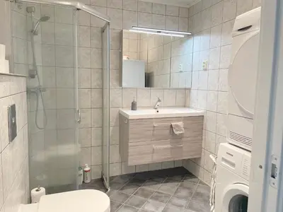 a bathroom with a shower and a sink and a toilet at Ålesund City Center - Modern 80-m2 flat with 3 bedrooms in Ålesund