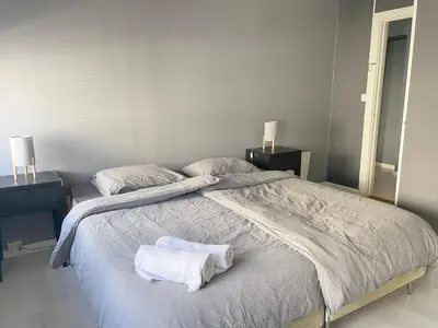 a bedroom with a large bed with two towels on it at Ålesund City Center - Modern 80-m2 flat with 3 bedrooms in Ålesund