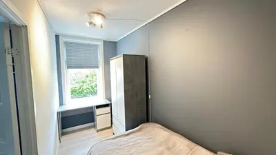 a small bedroom with a bed and a window at Ålesund City Center - Modern 80-m2 flat with 3 bedrooms in Ålesund