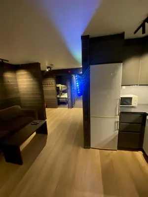 a kitchen with a refrigerator and a living room at Brobygget Mølla 101 in Kyrkjebøen