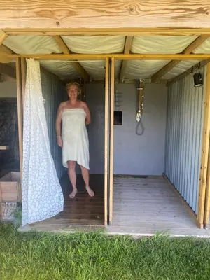 a woman standing inside of a covered porch at Raaum Gard, hytte 2 in Hafslo