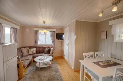 a living room with a couch and a table at Kvetos fjellgårdsutsikt in Beitostøl